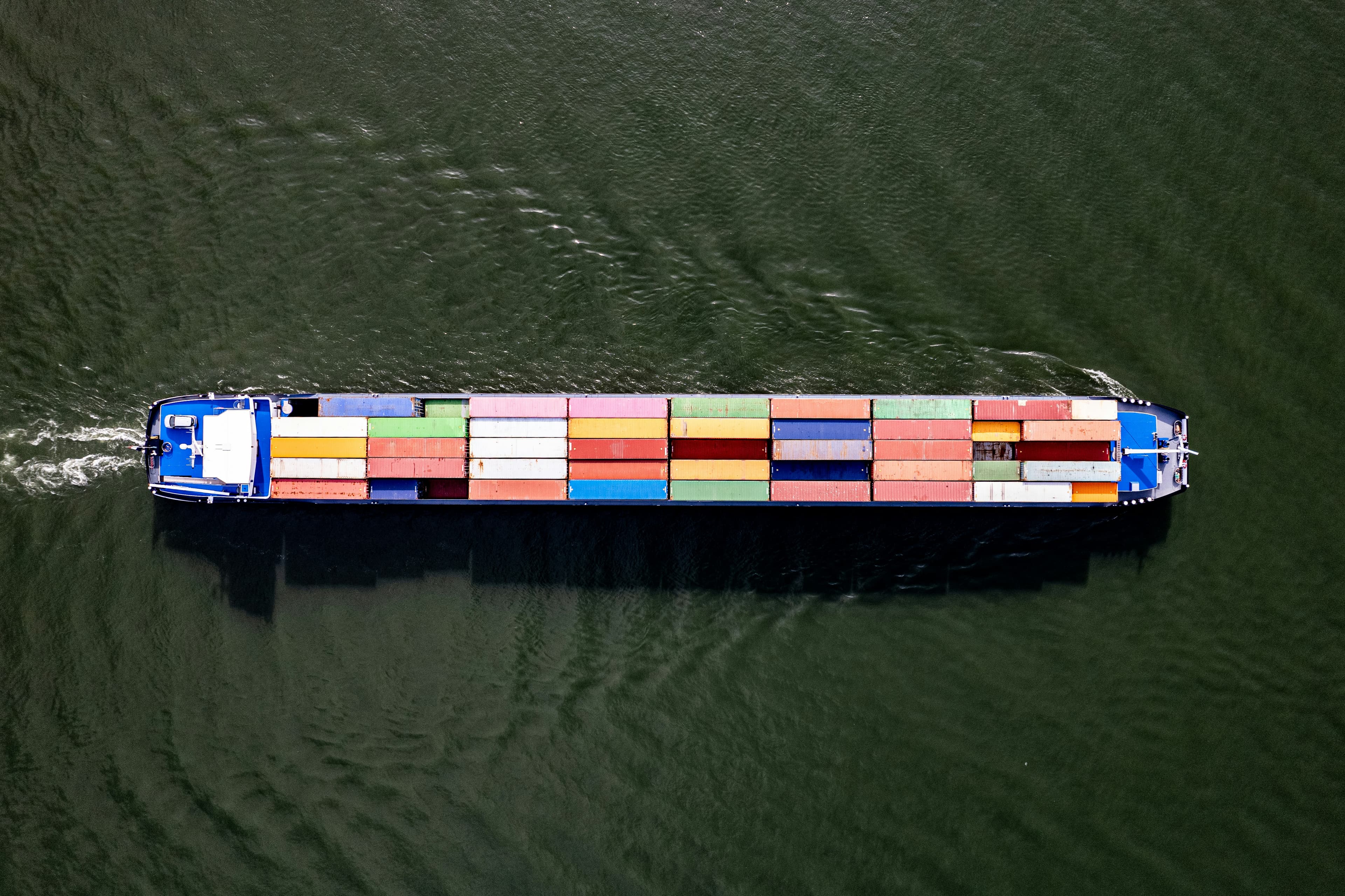 An aerial view of a large cargo ship with colorful containers.